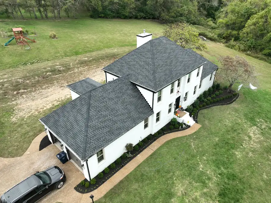 White home exterior with new roof, siding and gutters