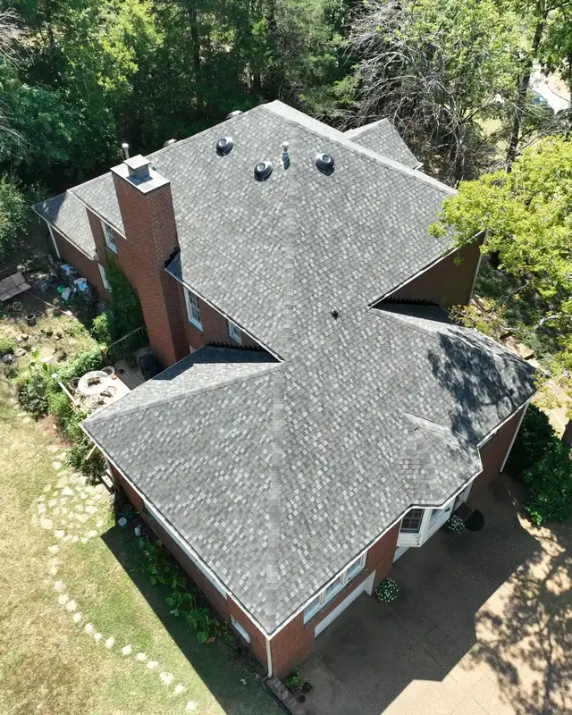 Drone view of a completed shingle roof replacement on a brick home