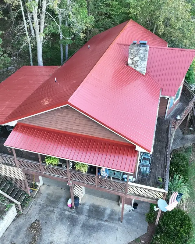Aerial view of a new red metal roof over a wraparound porch