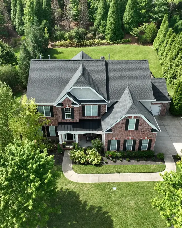 Front aerial view of a brick home with a new architectural shingle roof